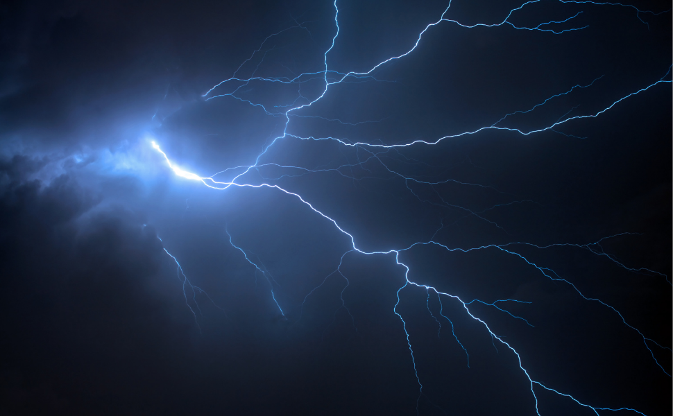 Bright lightning bolt branching across a dark storm sky, illustrating the intensity of a thunderstorm